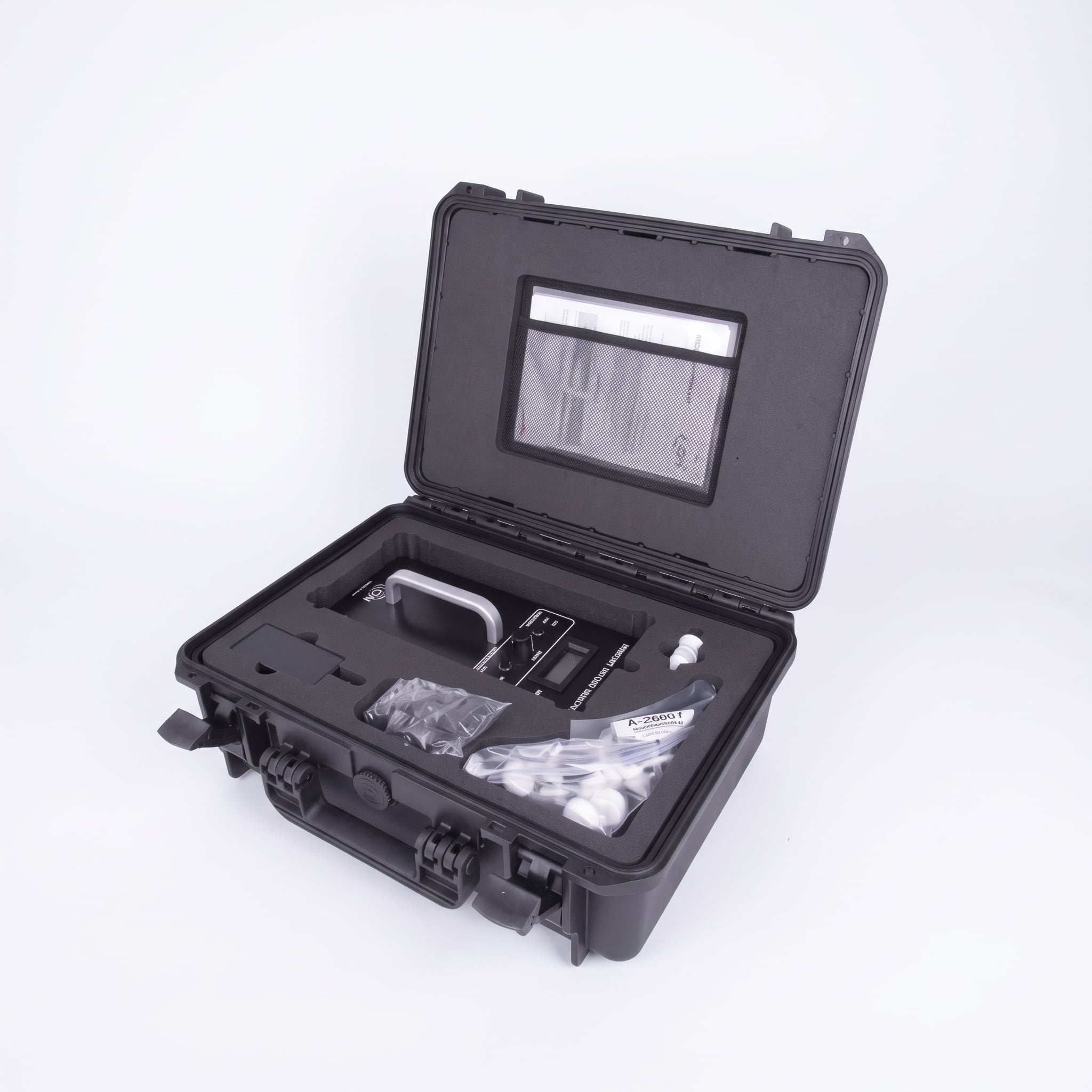 An open black protective carrying case containing an ION Science Mercury Vapour Indicator (MVI) and accessories, centered against a seamless white background. The upper lid is propped open, displaying a mesh document pocket, while the bottom section features custom-molded foam inserts holding the MVI device, spare parts, and filters in plastic packaging.