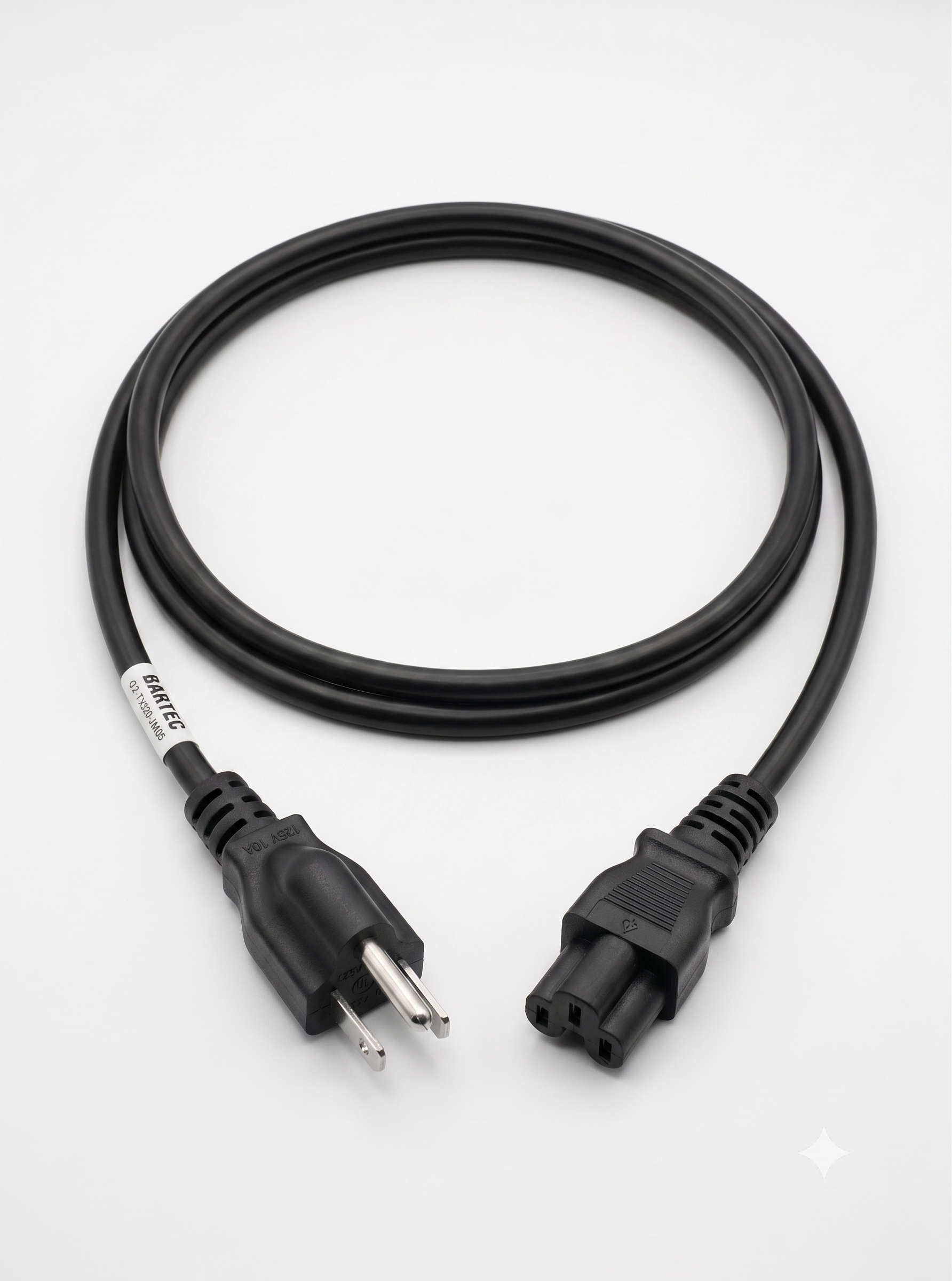 A black power cord with a 3-prong US plug on one end and a 3-slot C5 "cloverleaf" connector on the other, coiled into a single neat loop on a plain white background. A small white label with black text reading "BARTEC" is wrapped near the plug end