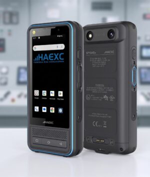 Front and back view of the HAEXC SP104Ex intrinsically safe smartphone, featuring a rugged black body with blue accent trim, physical navigation buttons, and hazardous-area safety markings against a blurred control room background