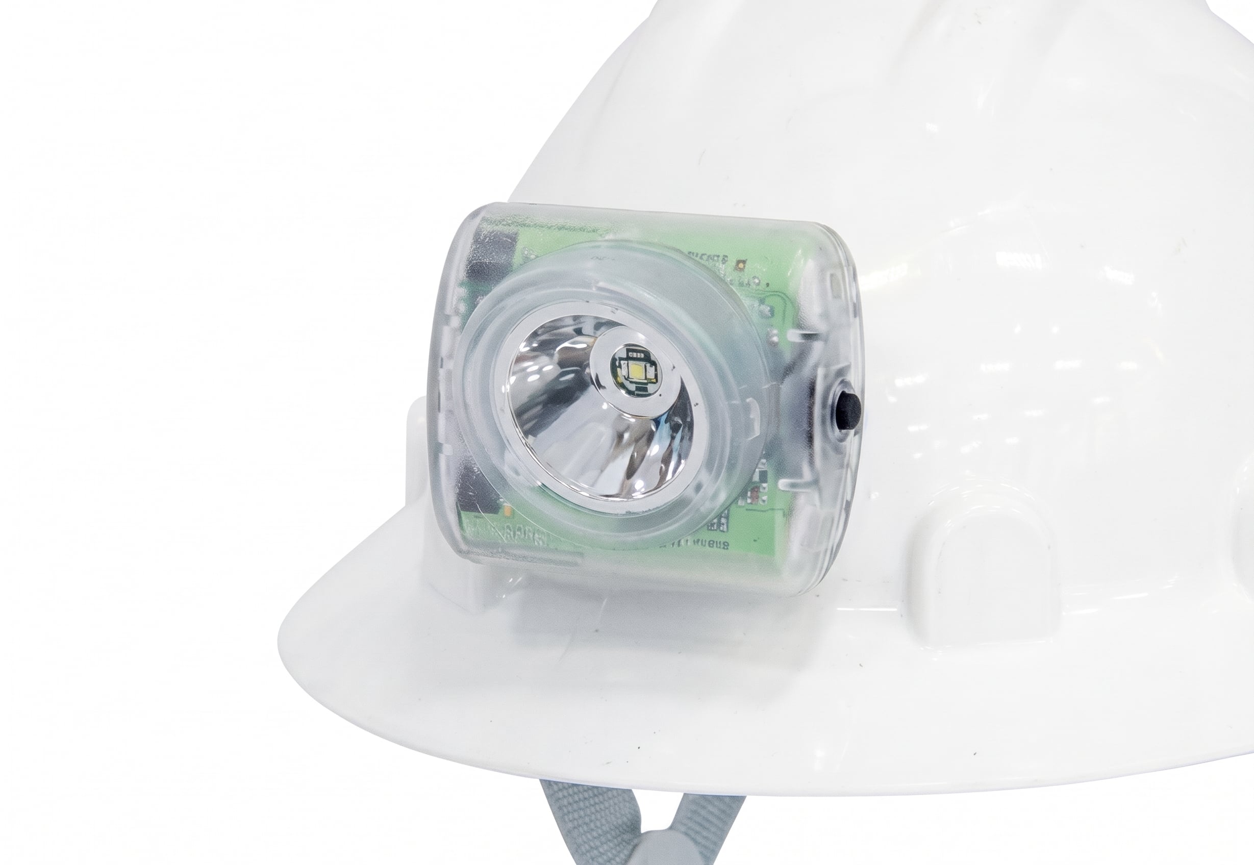 Close-up view of a clear-cased LED headlamp mounted to the front brim of a white construction hard hat.