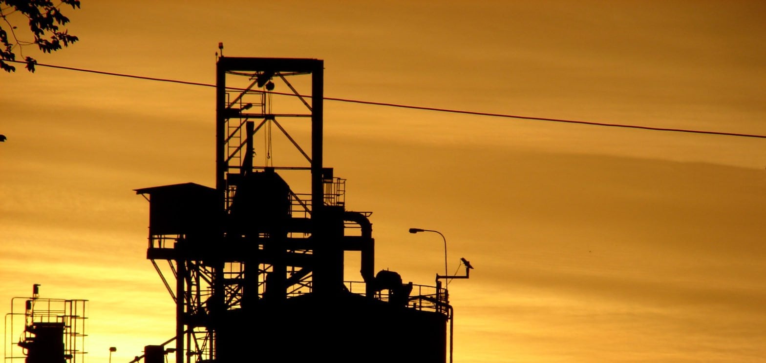 Sunset and Factory banner to introduce the topic: "What is the difference between Intrinsically Safe and Explosion-Proof"