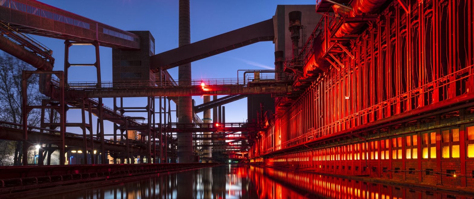 Banner picture of a refinery in the evening introducing the article topic